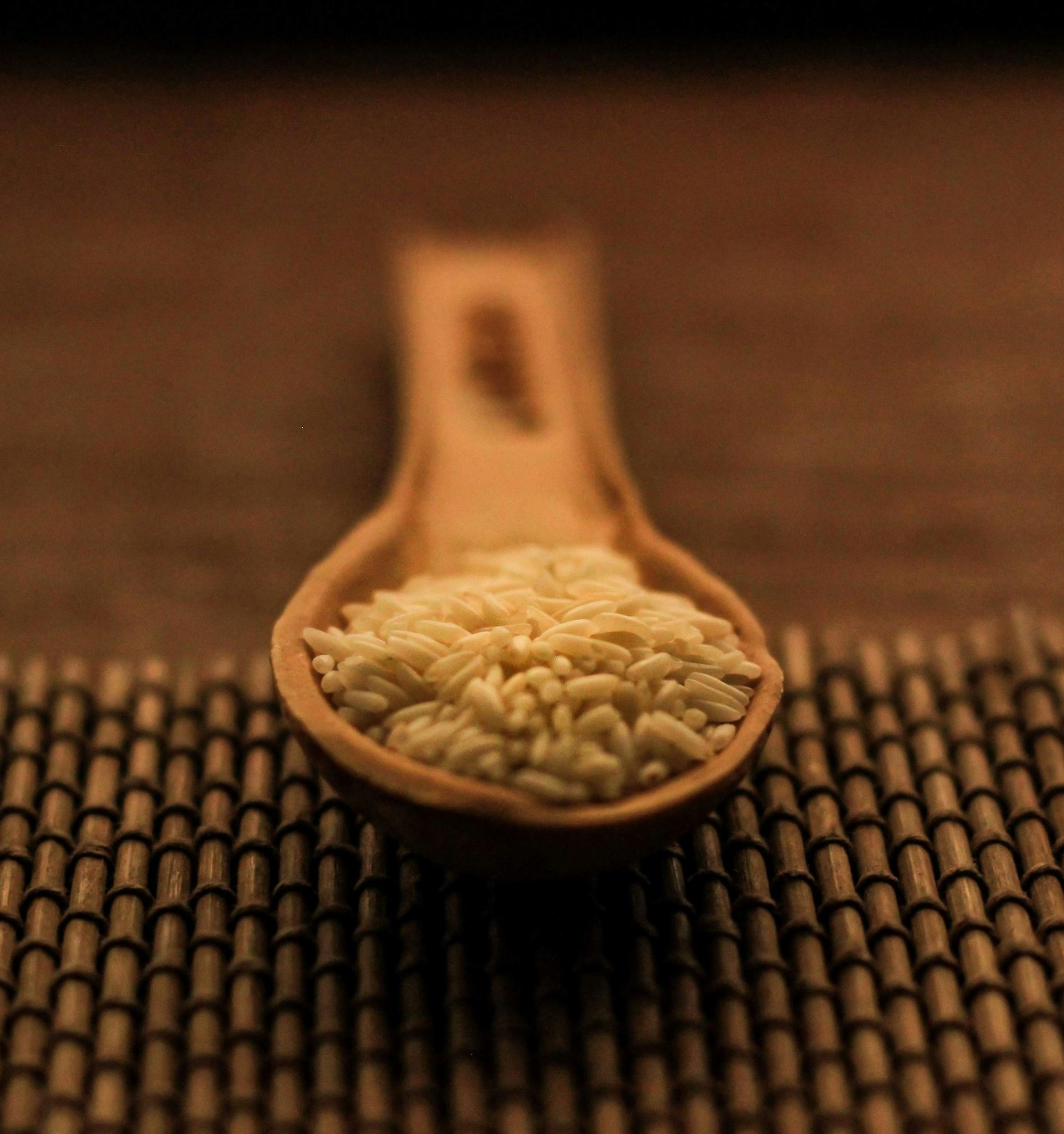 Golden parboiled rice on a wooden spoon